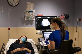 A resident using an ultrasound machine.