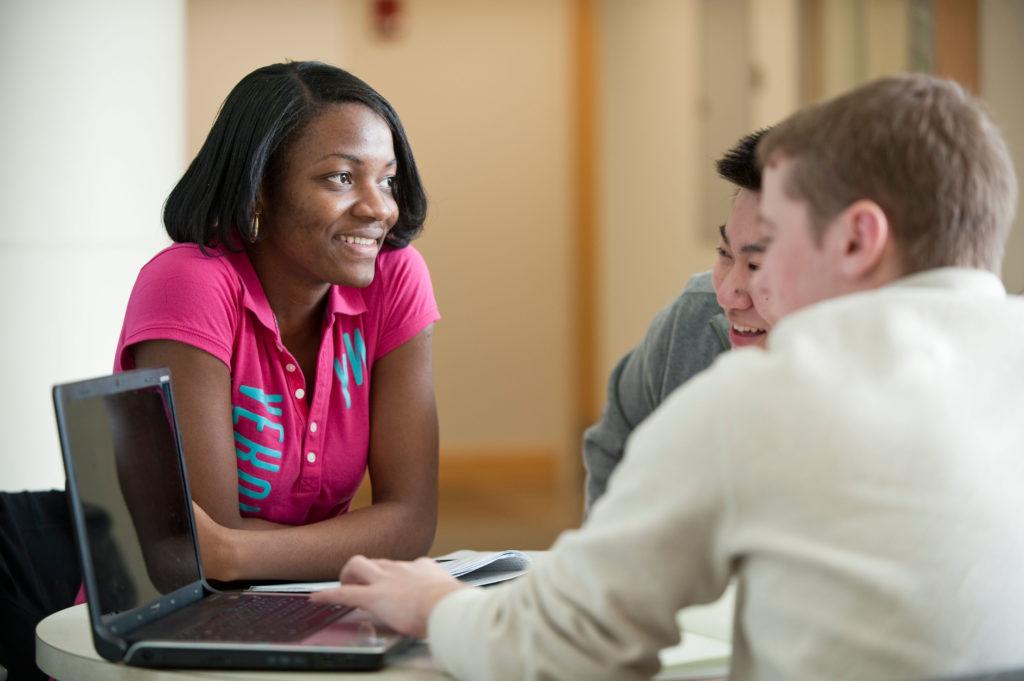 Three University of Rochester students collaborating on a computer